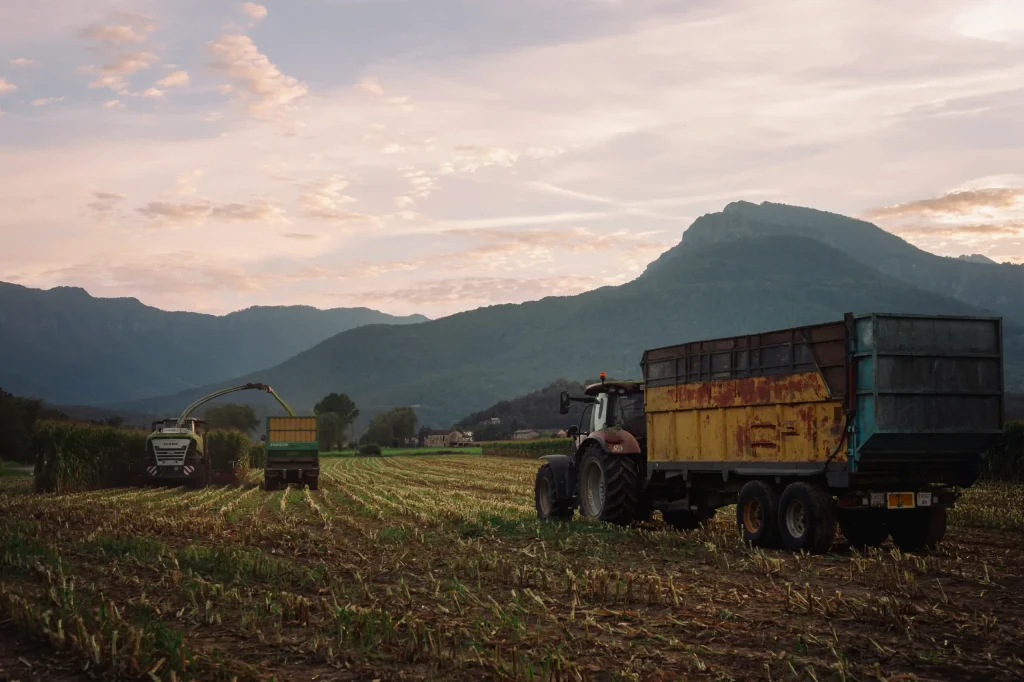 Imatge de vehicles agrícoles treballant amb un preciós paisatge de fons.